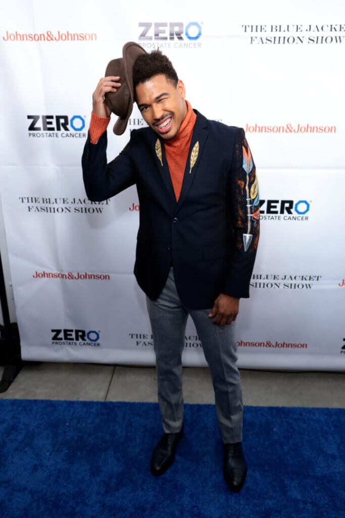 Man in a navy suit on a red carpet