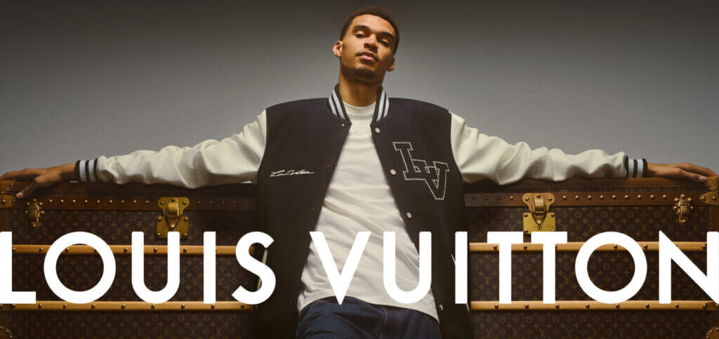 Man in Louis Vuitton in front of the brand sign