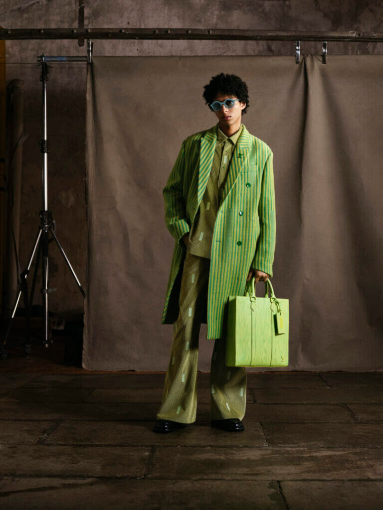 Model in a green suit with a lime bag