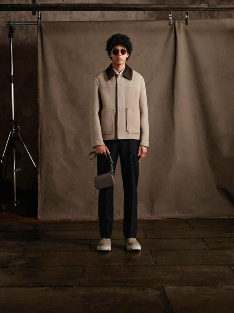 Model in a beige jacket and dark trousers