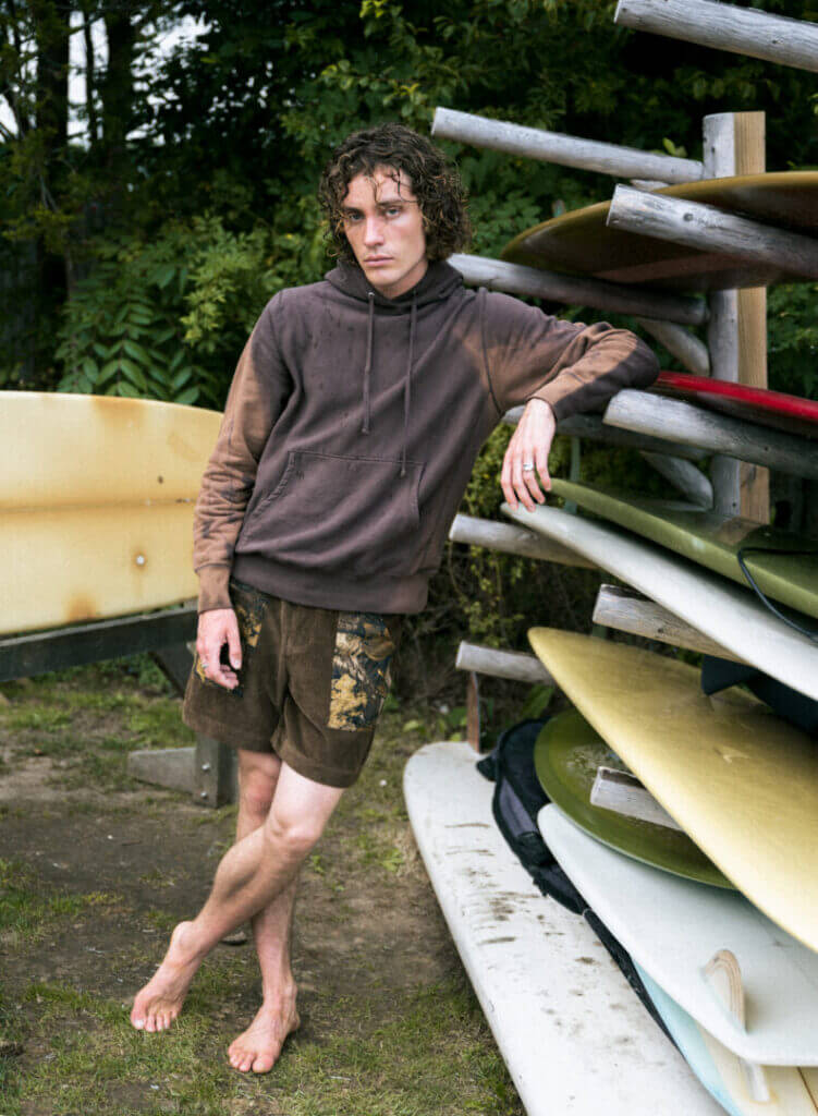 Model in a brown sweatshirt on a dock