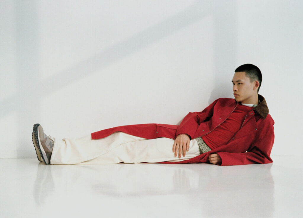 Man in red reclining on the floor in sneakers