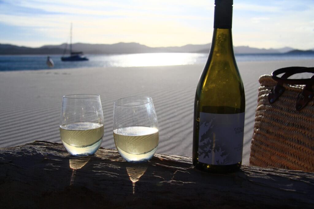 Two glasses of white wine overlooking a harbor