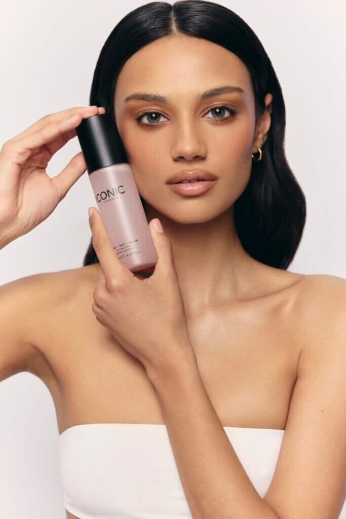 Woman holding a pink makeup bottle