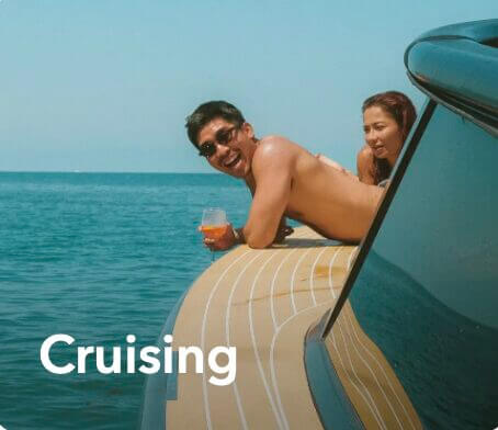 Couple leaning on a boat with the word Cruising