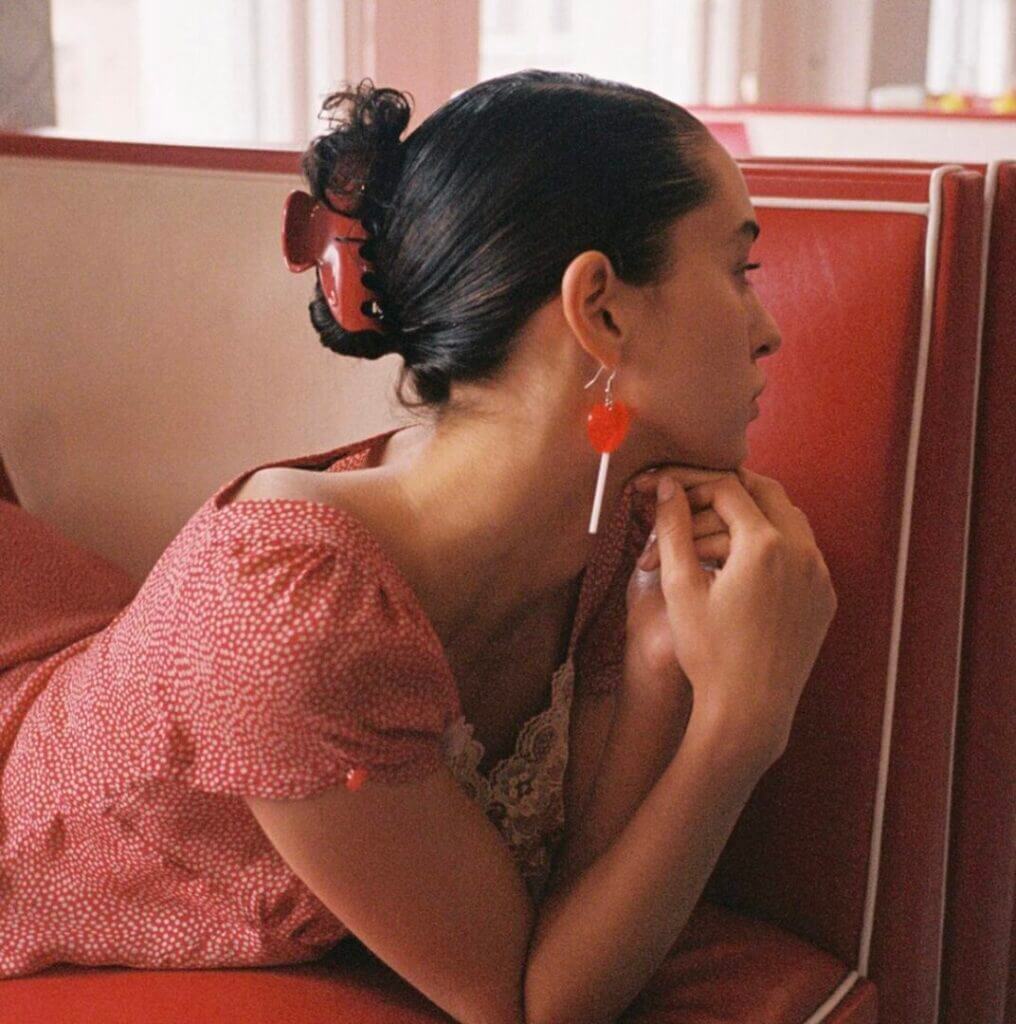 Woman in a red dress with a hair clip in a diner booth