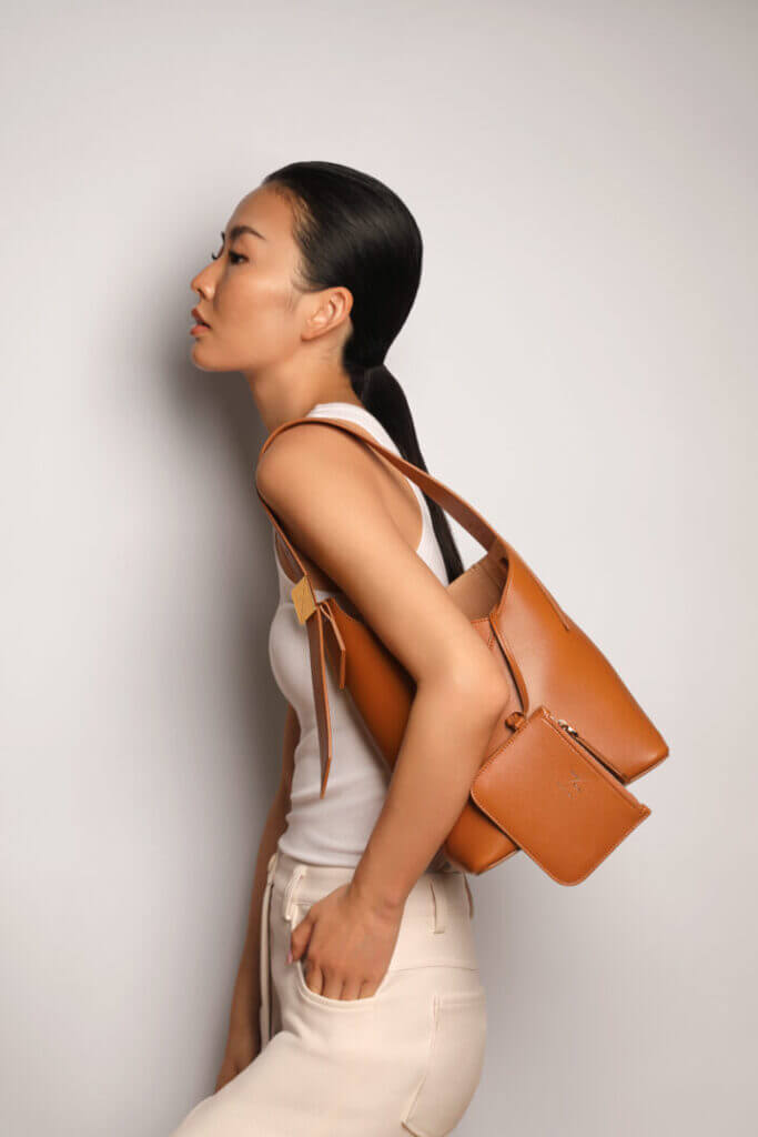 Woman carrying a tan shoulder bag