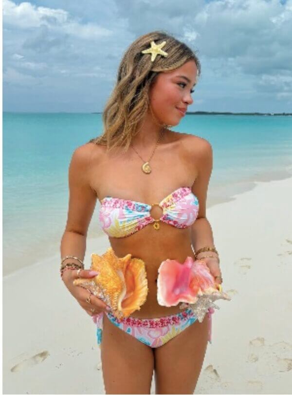 Woman in a bikini holding a pink puff