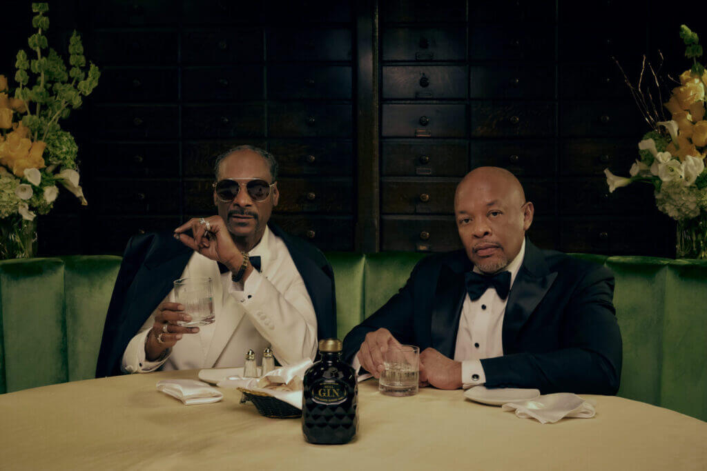 Two men at a table with a gin bottle