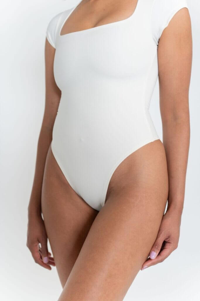 Model in a white short-sleeve bodysuit