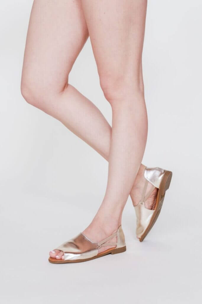 Woman's legs in gold sandals