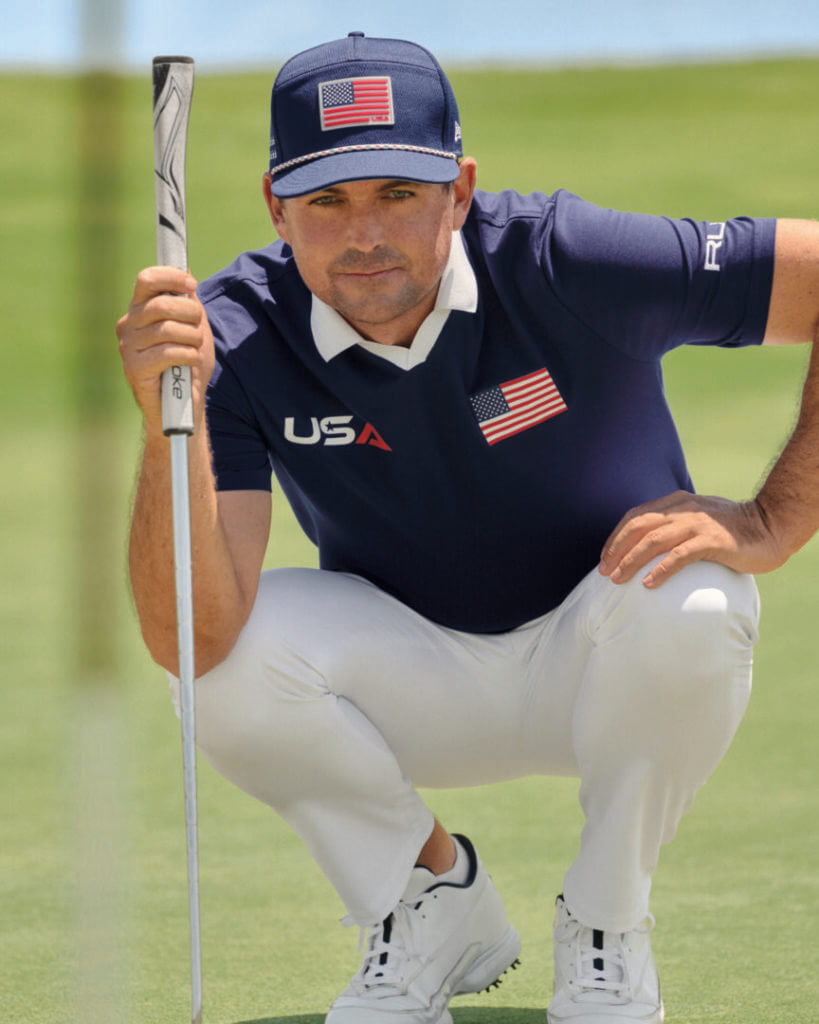 Golfer in a navy USA polo crouching on a green