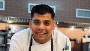 Smiling chef in a white jacket at STK Steakhouse NYC
